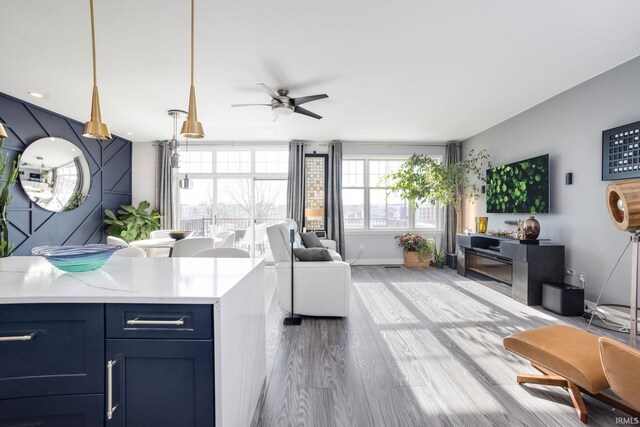 living room with ceiling fan and light hardwood / wood-style floors