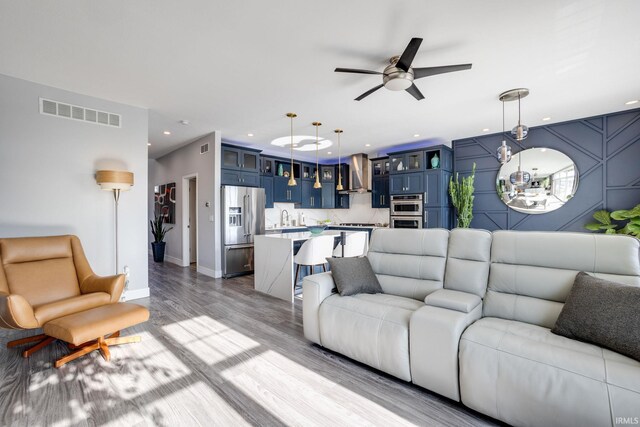 living room with ceiling fan and light hardwood / wood-style floors