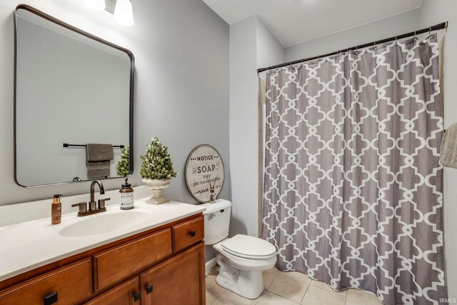 bathroom with tile patterned flooring, vanity, and toilet