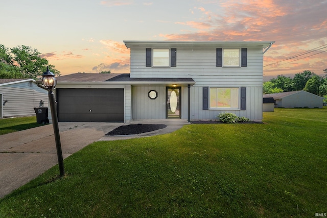 front of property featuring a lawn and a garage