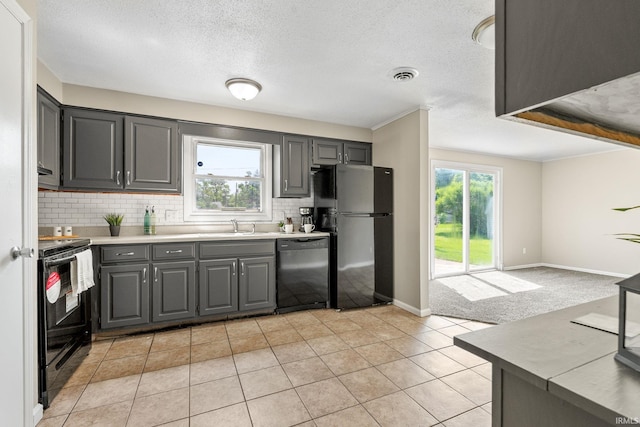 kitchen featuring light tile patterned floors, a healthy amount of sunlight, black appliances, and gray cabinets