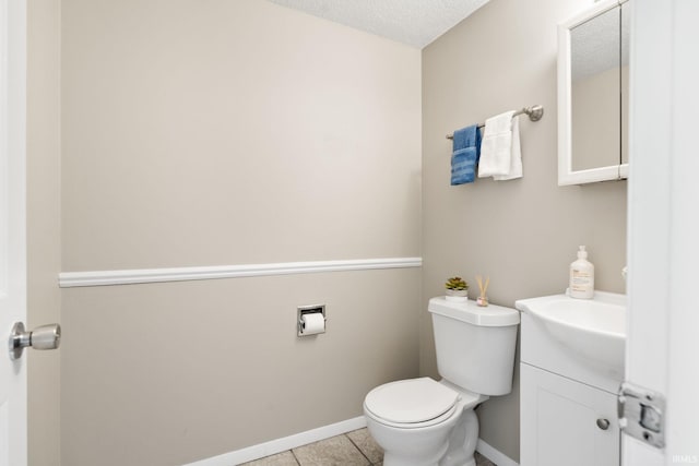 bathroom featuring toilet, tile patterned flooring, vanity, and a textured ceiling