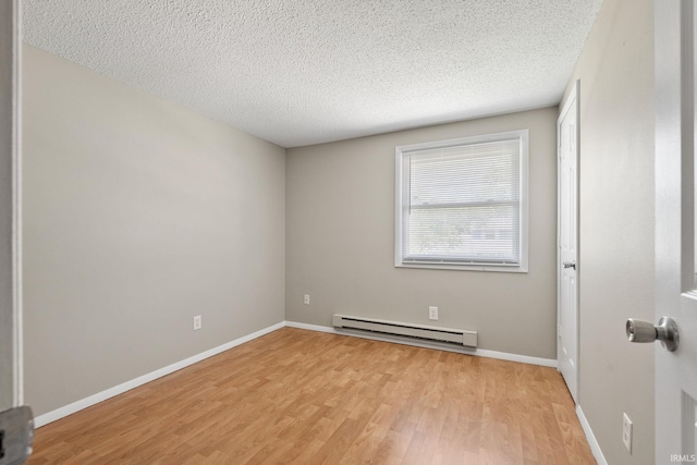 unfurnished room with a baseboard radiator, a textured ceiling, and light hardwood / wood-style flooring