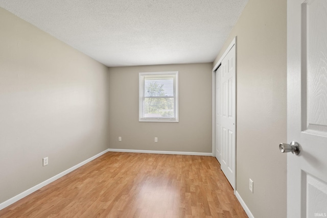 unfurnished bedroom with a textured ceiling and light hardwood / wood-style floors