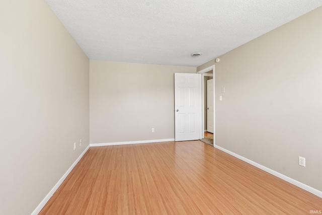 spare room with a textured ceiling and hardwood / wood-style flooring