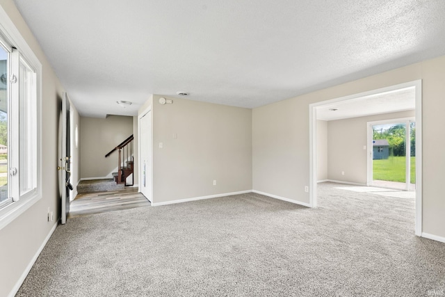 empty room featuring a textured ceiling and light carpet