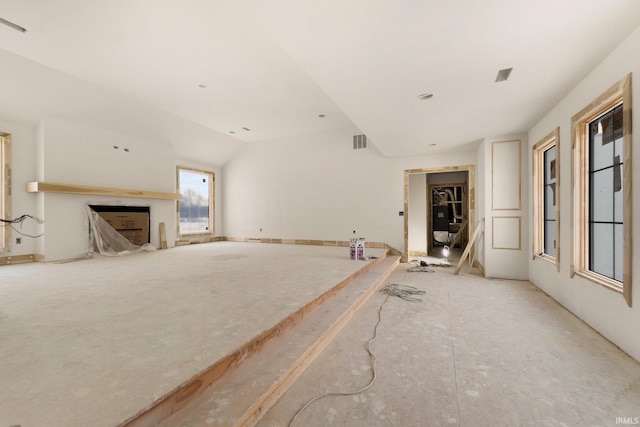 unfurnished living room with a fireplace and vaulted ceiling