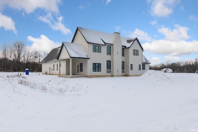 view of snow covered back of property