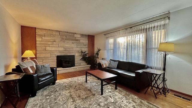 living room featuring wood-type flooring and a wood stove