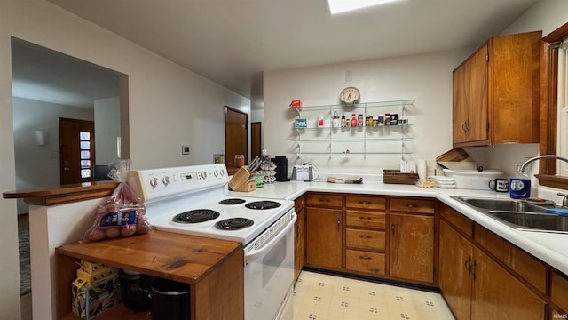 kitchen featuring sink, electric stove, and kitchen peninsula