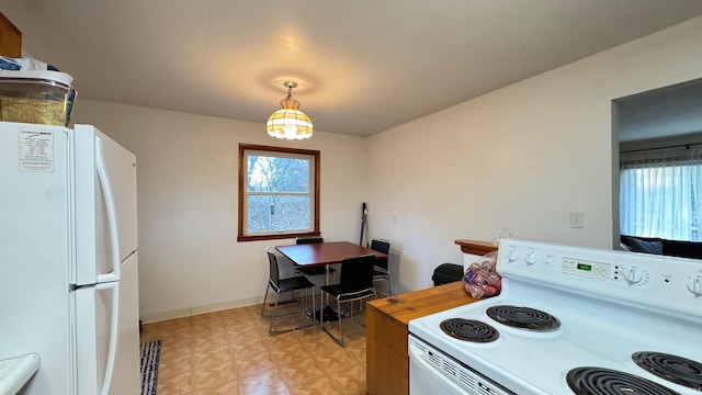 kitchen with white appliances and hanging light fixtures