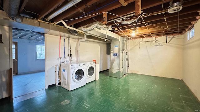 laundry room featuring electric panel, washer and dryer, and heating unit