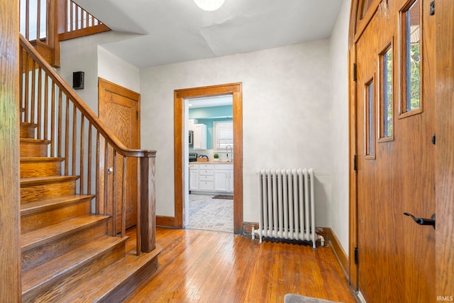 entryway featuring radiator, a healthy amount of sunlight, and hardwood / wood-style floors