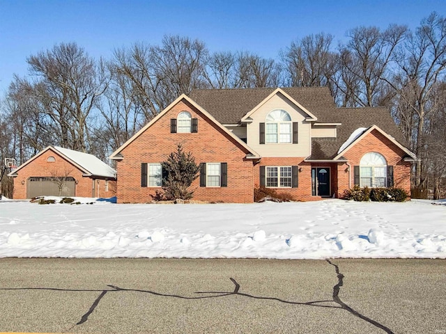 traditional-style home with a garage, roof with shingles, and brick siding