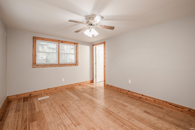 empty room with ceiling fan and light hardwood / wood-style flooring