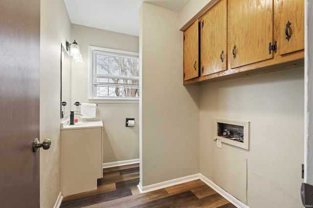 laundry room with sink, dark hardwood / wood-style flooring, hookup for a washing machine, and cabinets