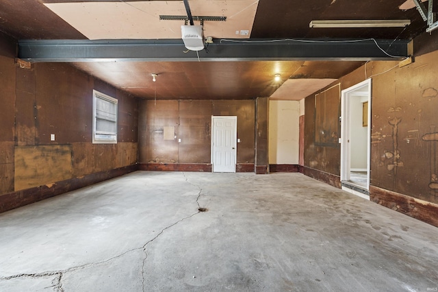 garage with a garage door opener and wooden walls