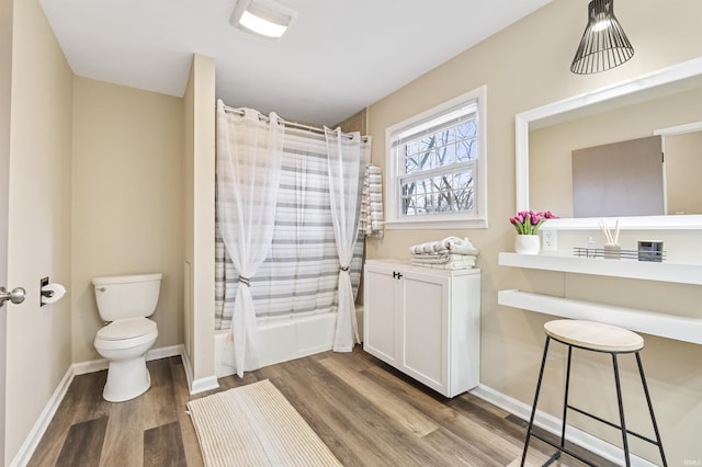 bathroom featuring toilet, shower / bath combination with curtain, and hardwood / wood-style floors