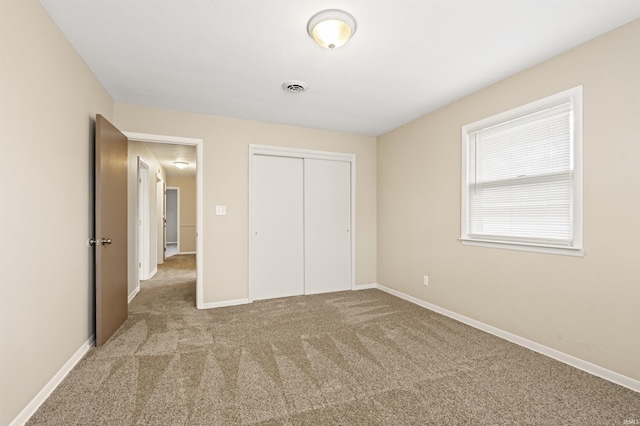 unfurnished bedroom with a closet and light carpet