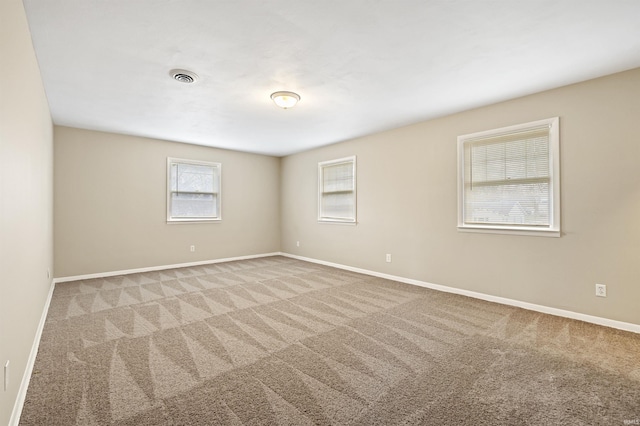 carpeted spare room featuring plenty of natural light