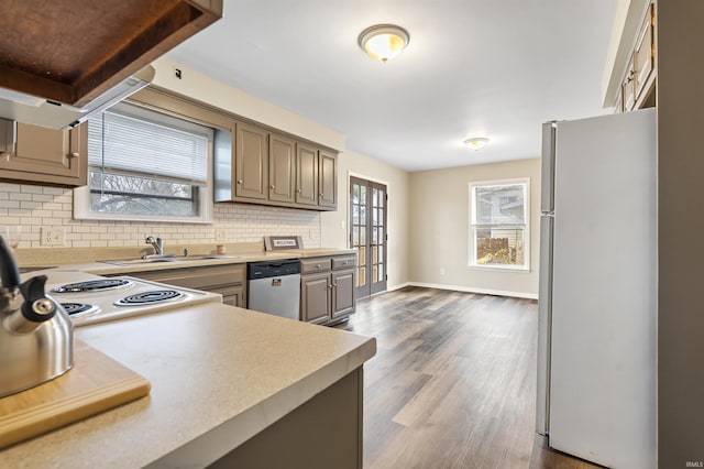 kitchen featuring appliances with stainless steel finishes, dark wood-type flooring, tasteful backsplash, and sink