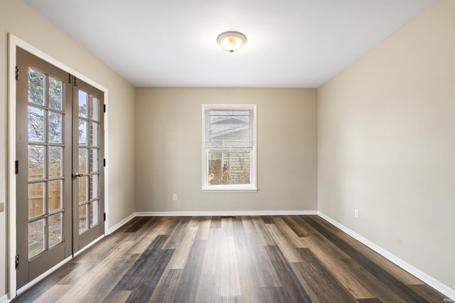 empty room featuring french doors and dark hardwood / wood-style flooring