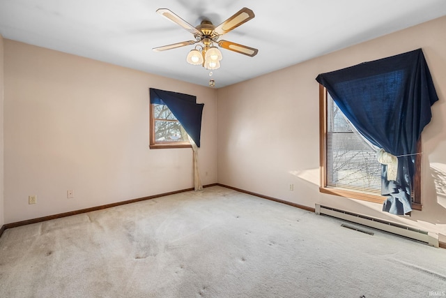 empty room featuring ceiling fan, baseboard heating, and carpet flooring