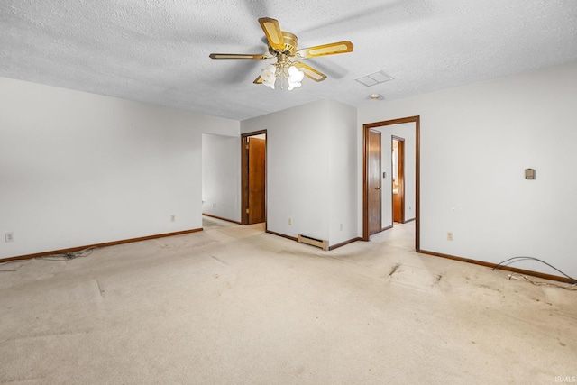 carpeted empty room featuring ceiling fan, a textured ceiling, and a baseboard heating unit