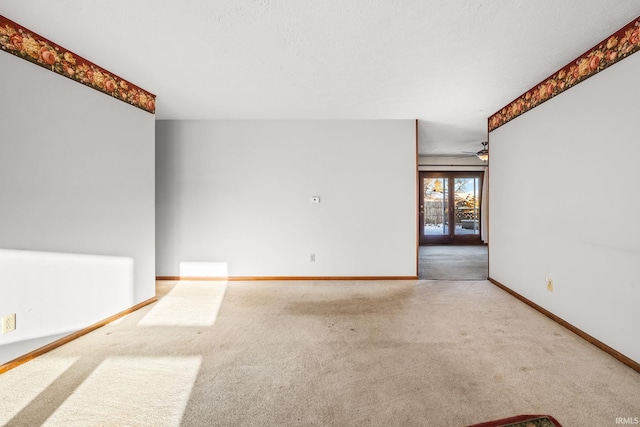 empty room featuring ceiling fan and light carpet