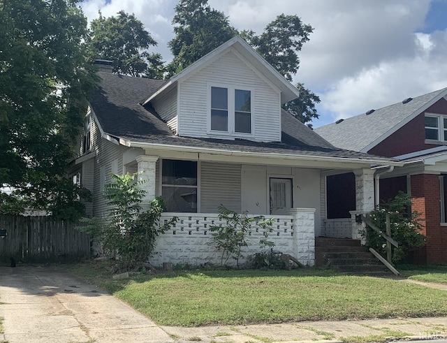 view of front of house with covered porch and a front lawn