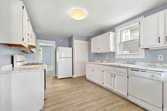 kitchen featuring white appliances, white cabinets, light hardwood / wood-style flooring, and sink