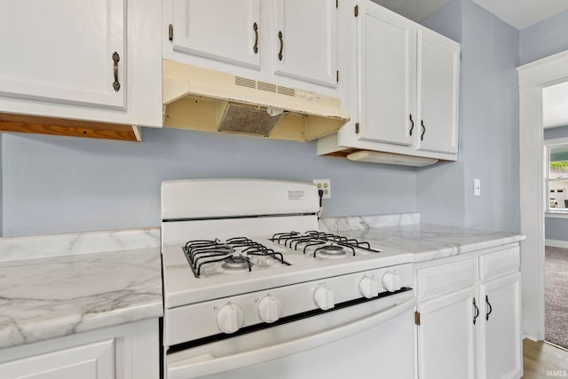 kitchen with carpet flooring, white cabinetry, white range with gas cooktop, and light stone counters