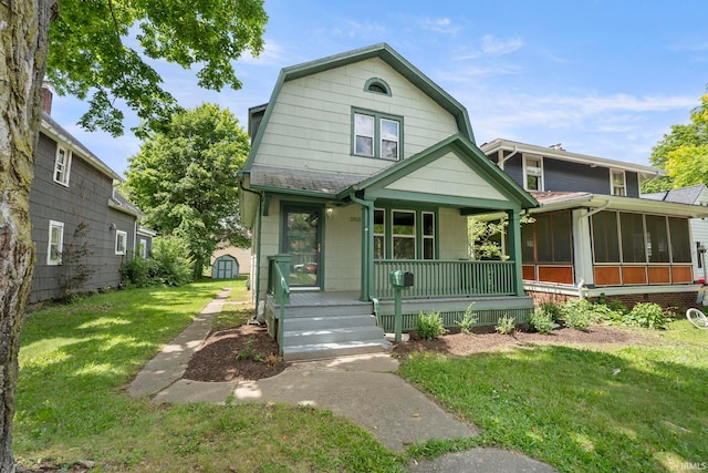 view of front of property with a front yard, a porch, and a sunroom