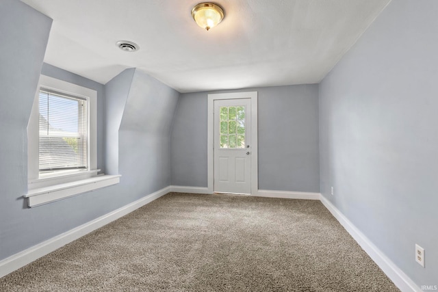 bonus room with lofted ceiling and carpet flooring