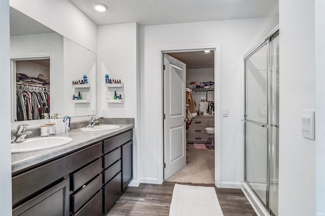 bathroom with a shower with door, vanity, and hardwood / wood-style flooring