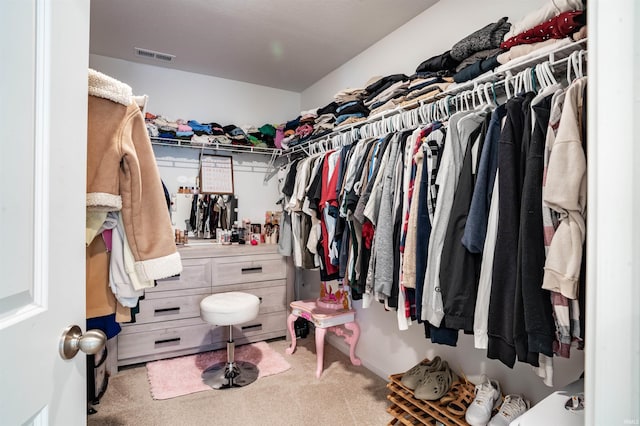 walk in closet featuring light colored carpet