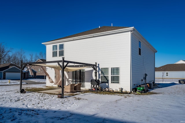 snow covered house featuring a pergola