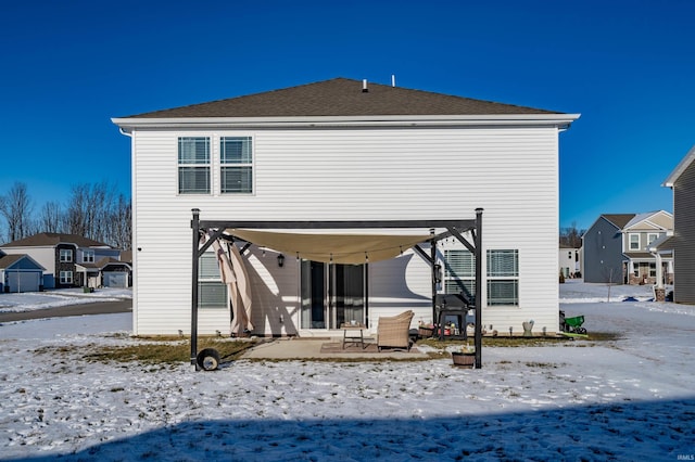 snow covered house featuring a patio