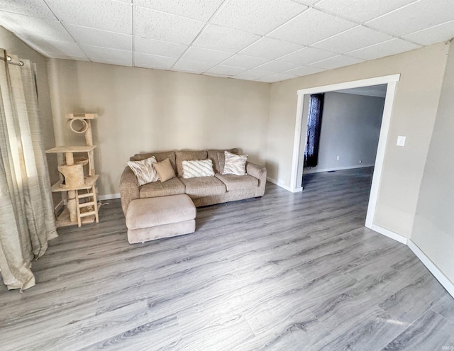 unfurnished living room with a paneled ceiling and wood-type flooring