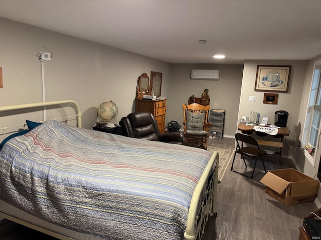 bedroom with hardwood / wood-style flooring and a wall unit AC