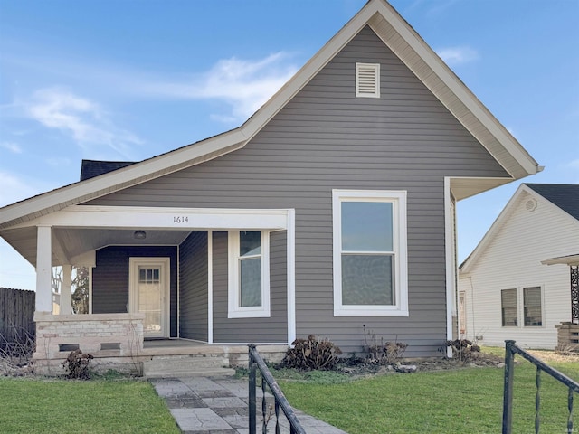 bungalow-style home with a front yard and covered porch