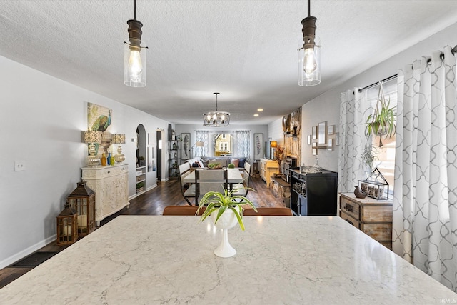 dining room with dark hardwood / wood-style flooring, a textured ceiling, and a chandelier