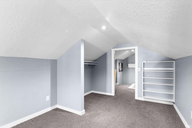 walk in closet with lofted ceiling and dark colored carpet