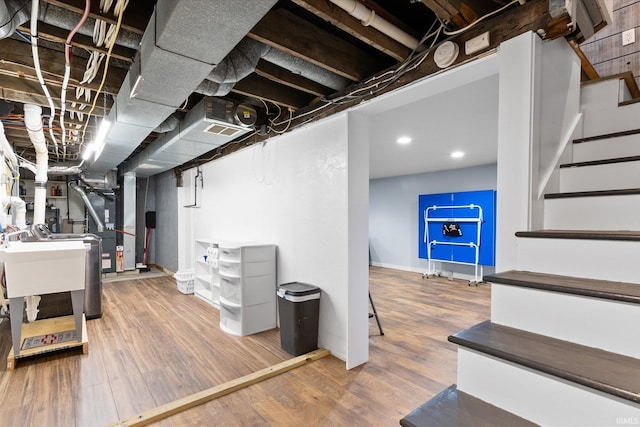 basement with sink and hardwood / wood-style flooring