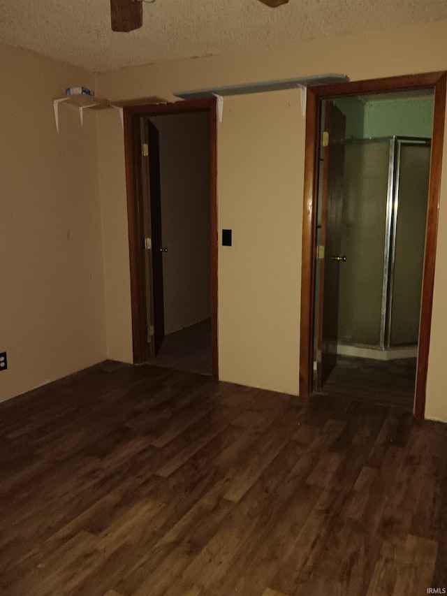 unfurnished room featuring a textured ceiling, ceiling fan, and dark hardwood / wood-style flooring