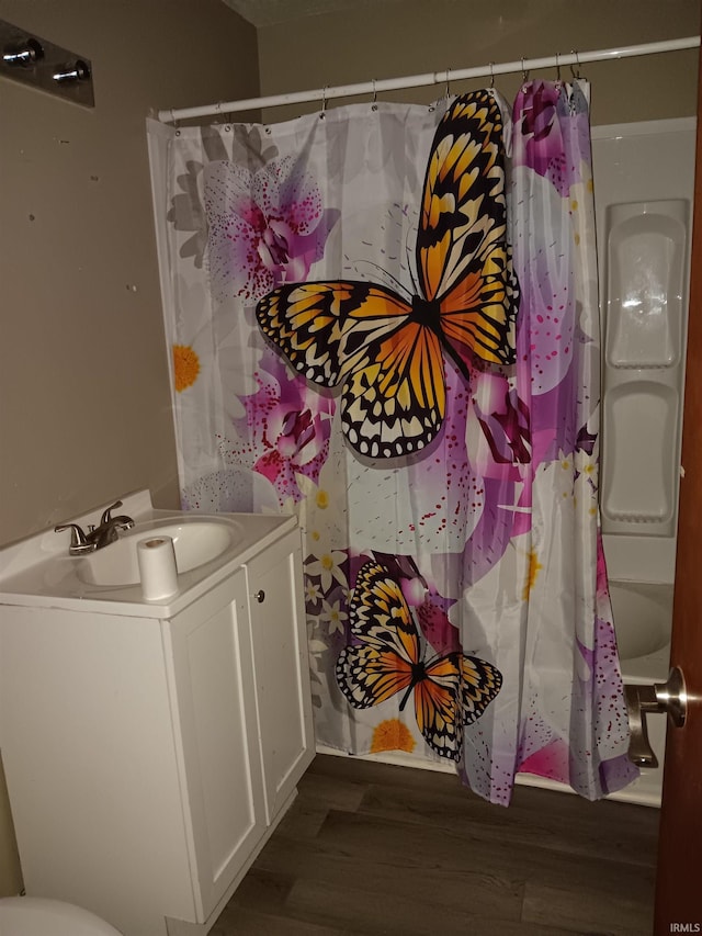 bathroom with shower / tub combo with curtain, vanity, and hardwood / wood-style flooring