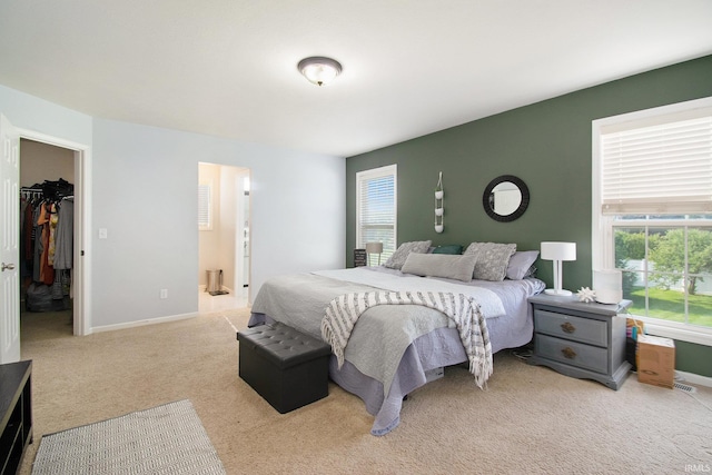 bedroom featuring light colored carpet and connected bathroom