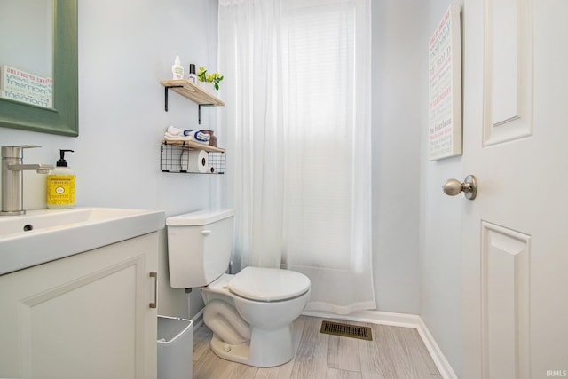 bathroom with hardwood / wood-style floors, vanity, and toilet