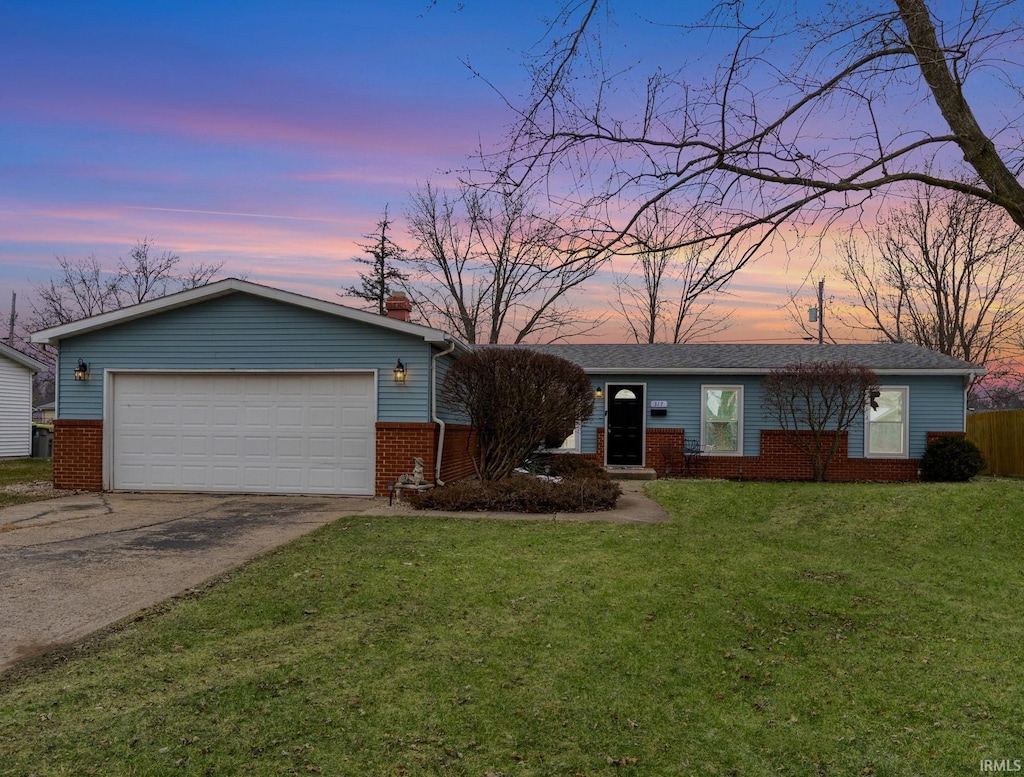 ranch-style home featuring a yard and a garage