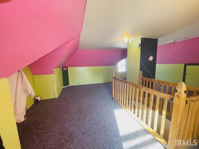 bonus room with lofted ceiling and carpet flooring